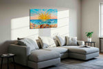 Sunburst Over Coral Tides beach canvas wall art displayed above a sofa in a styled living room scene