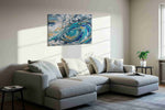 Gilded Tempest Spiral coastal canvas wall art displayed above a sofa in a styled living room scene