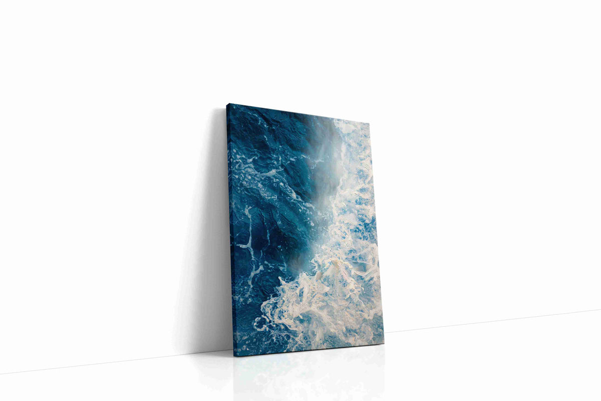 Where Foam Meets Midnight coastal canvas wall art displayed above a sofa in a modern living room