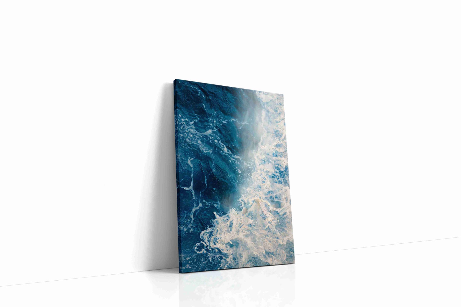 Where Foam Meets Midnight coastal canvas wall art displayed above a sofa in a modern living room